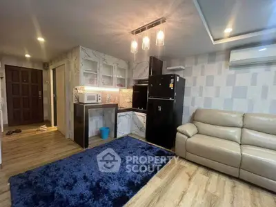Modern living room with open kitchen, featuring sleek appliances and stylish lighting, perfect for urban living.