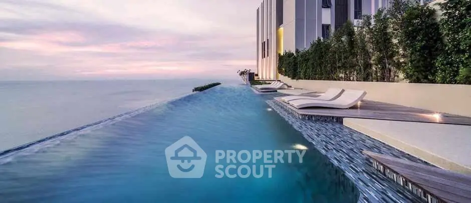 Luxurious infinity pool with ocean view at modern high-rise building.