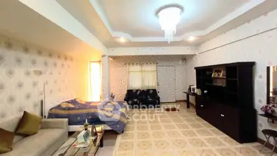 Spacious bedroom with elegant chandelier and cozy seating area