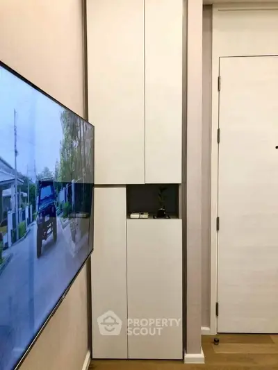 Modern living room with sleek storage and wall-mounted TV in a stylish apartment.