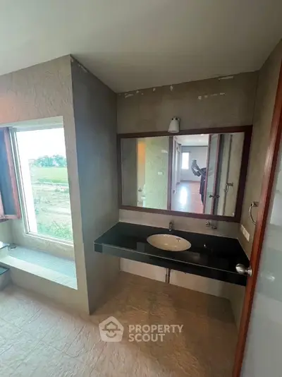 Modern bathroom with large window and sleek vanity in a stylish home
