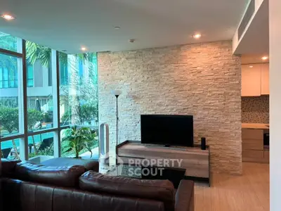 Modern living room with large windows and stylish stone accent wall