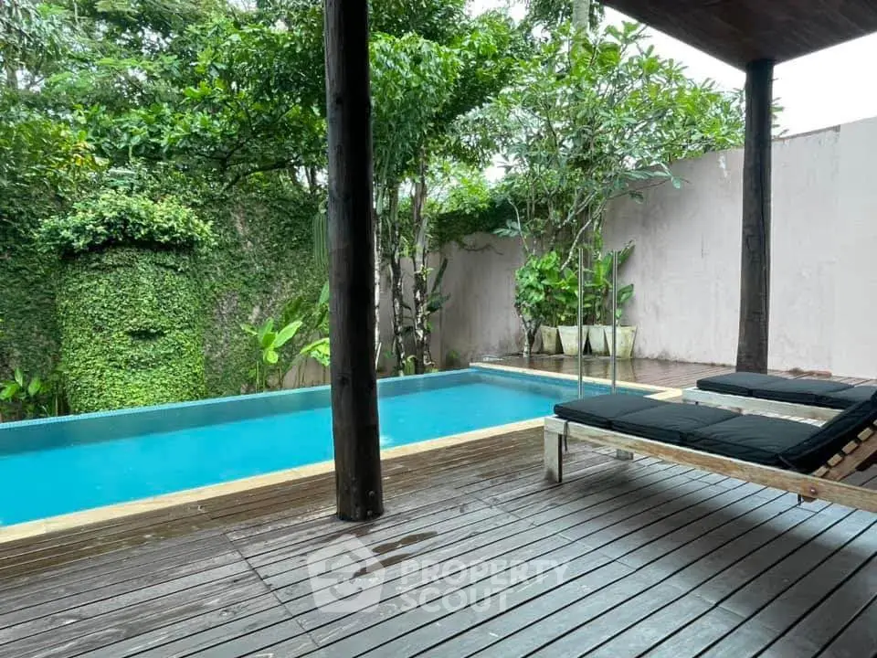Luxurious private pool with wooden deck and lush greenery, perfect for relaxation and leisure.