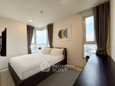 Modern bedroom with large windows offering stunning city views and stylish decor.