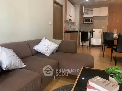 Modern living room with cozy brown sofa and open kitchen layout