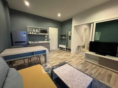 Modern living room with open kitchen, stylish decor, and cozy seating area in a contemporary apartment.