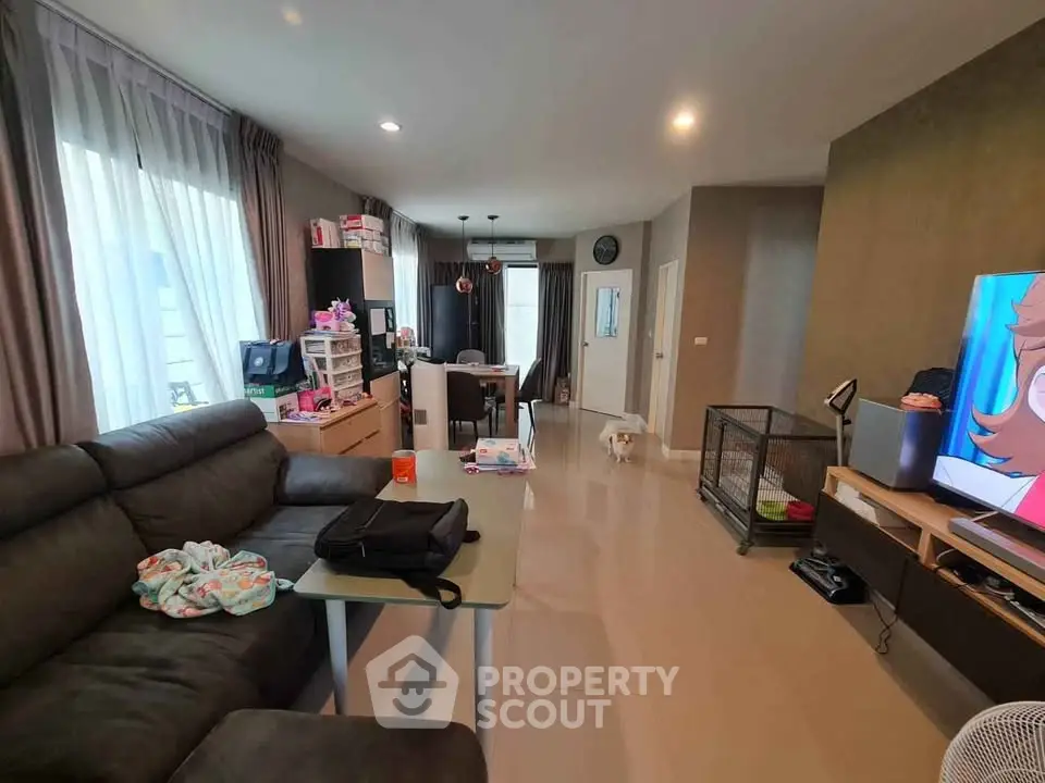 Spacious living room with modern decor and ample natural light, perfect for family gatherings.