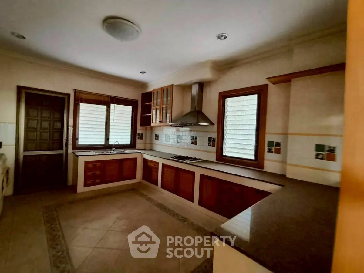 Spacious kitchen with modern cabinetry and gas stove in a cozy home setting.