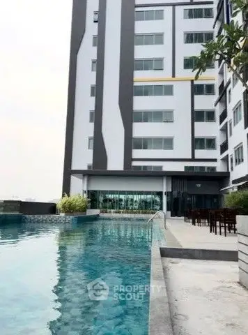 Modern apartment building with a luxurious poolside view, perfect for urban living.