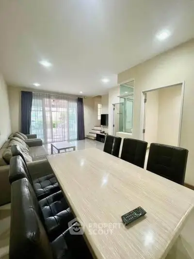 Spacious modern living room with dining area and natural light, perfect for family gatherings.