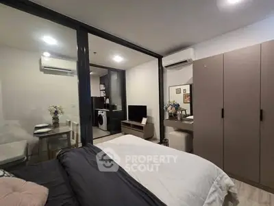 Modern studio apartment with open layout, featuring a cozy bedroom, compact kitchen, and stylish decor.