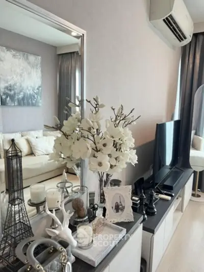 Elegantly styled living room with chic decor and modern amenities, featuring a plush sofa, sleek TV unit, and tasteful art.