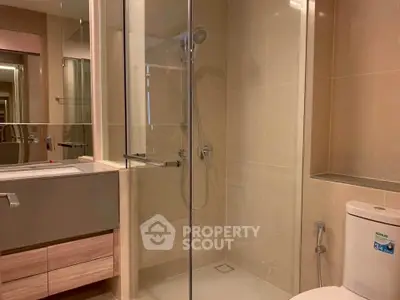 Modern bathroom with glass shower and sleek fixtures in a contemporary apartment.