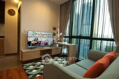 Modern living room with large windows and stylish furniture in a high-rise apartment.