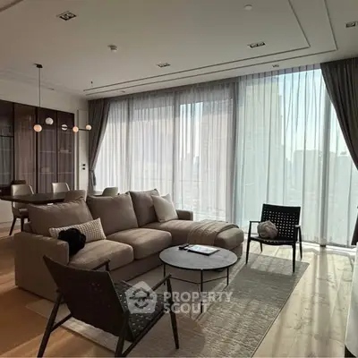 Luxurious modern living room with floor-to-ceiling windows and elegant furnishings in a high-rise apartment.