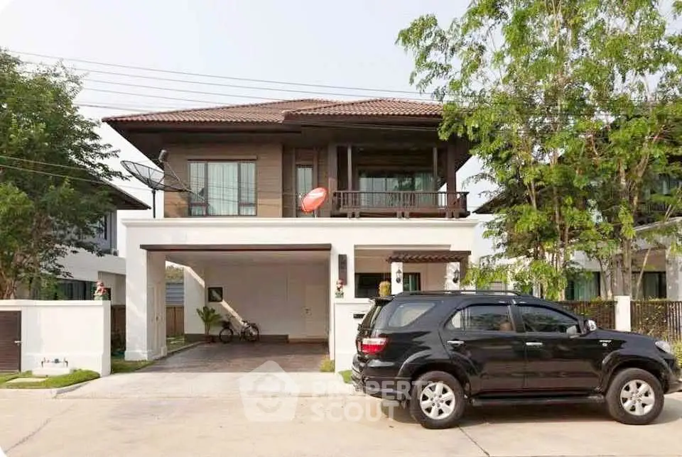 Charming two-story house with spacious driveway and lush greenery