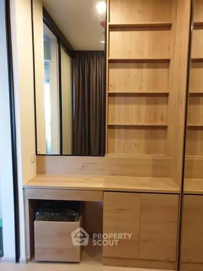 Modern wooden storage unit with mirror and shelves in a stylish interior.