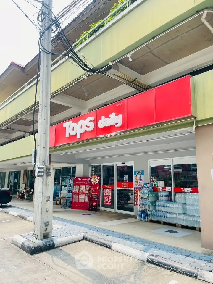 Street view of a commercial building with a Tops Daily store, showcasing retail space availability.