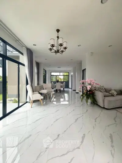 Luxurious open-plan living room with elegant chandelier and marble flooring
