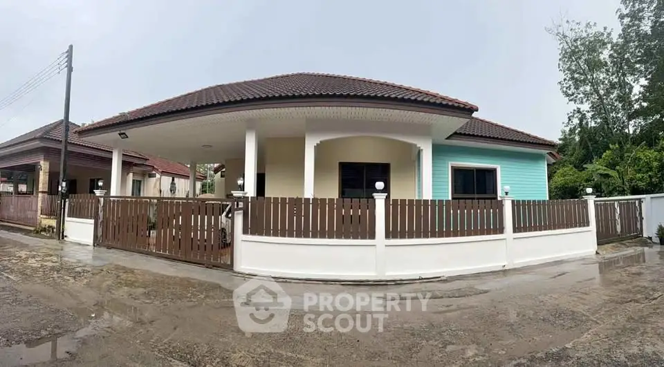Charming single-story house with a fenced yard and tiled roof in a serene neighborhood.