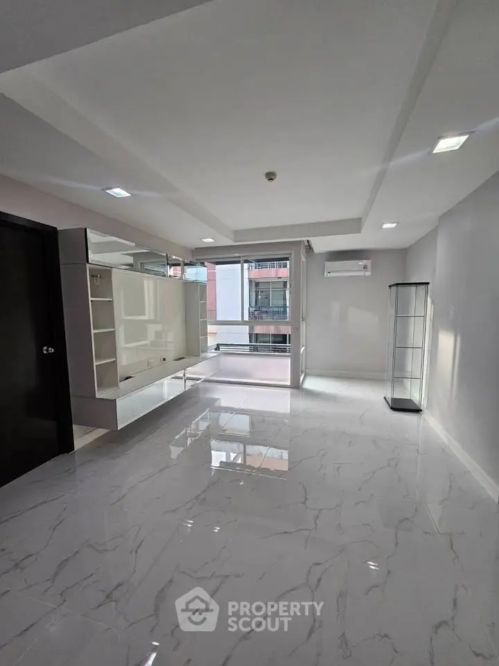 Spacious modern living room with glossy marble floors and large windows.