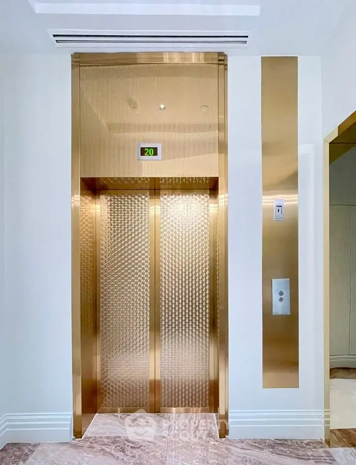 Luxurious golden elevator in modern building with elegant design and high-end finishes.
