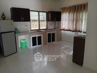 Spacious kitchen with modern cabinets and large windows for natural light.