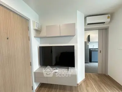 Modern living room with sleek TV unit and air conditioning in a stylish apartment.