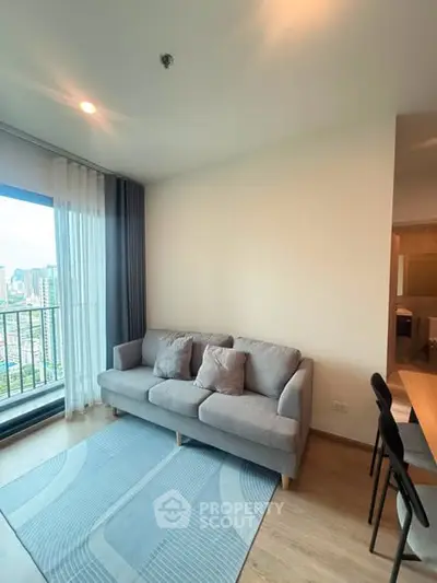 Modern living room with city view and cozy gray sofa in high-rise apartment