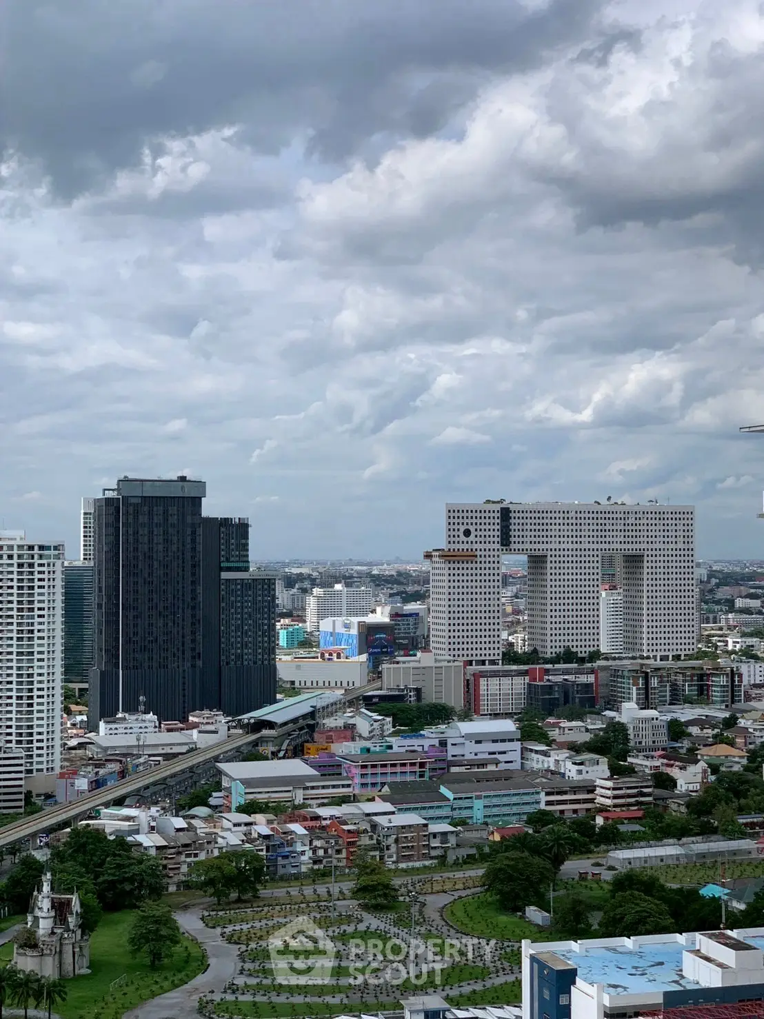 Stunning cityscape view with modern high-rise buildings under a cloudy sky.