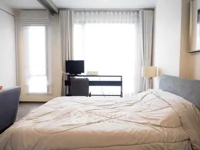 Modern bedroom with cozy bed and work desk near large window