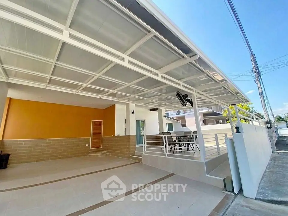 Modern home exterior with spacious carport and sleek design in a sunny neighborhood.