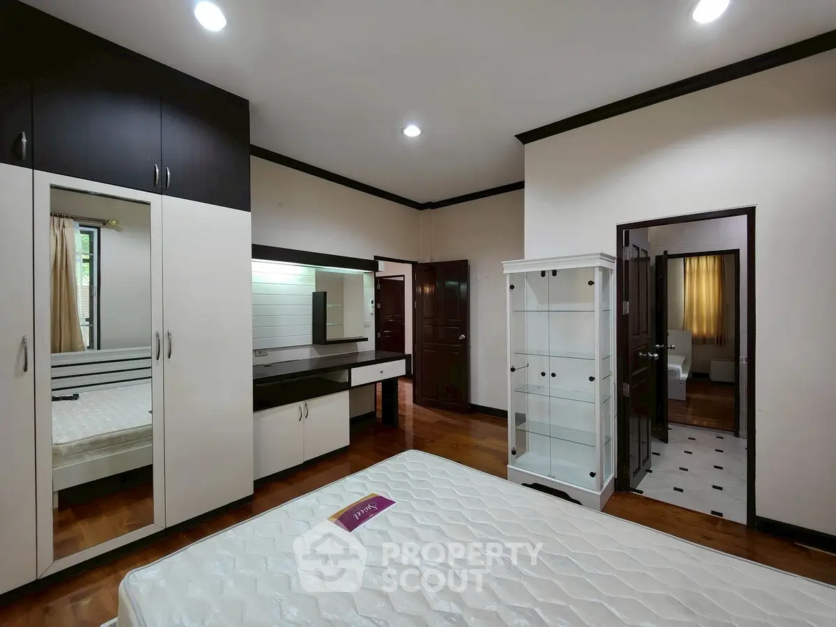 Spacious bedroom with modern furniture and ample storage space
