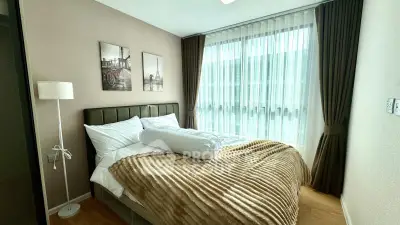 Cozy bedroom with large window and elegant decor in modern apartment