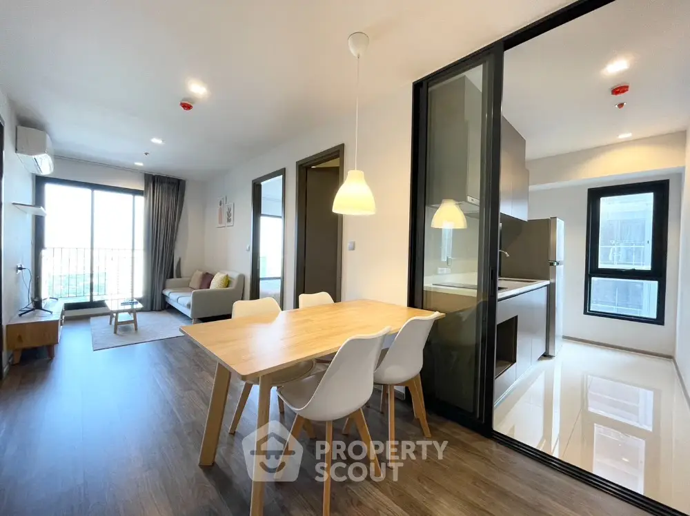 Modern open-plan living room and kitchen with stylish furniture and large windows