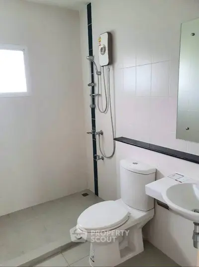 Modern bathroom with shower, toilet, and sink in a minimalist design.