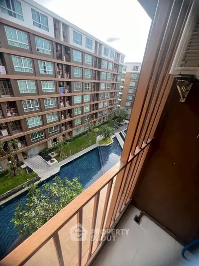 Modern apartment balcony with pool view in urban setting