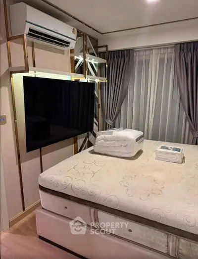 Modern bedroom with stylish decor, featuring a mounted TV and air conditioning for ultimate comfort.