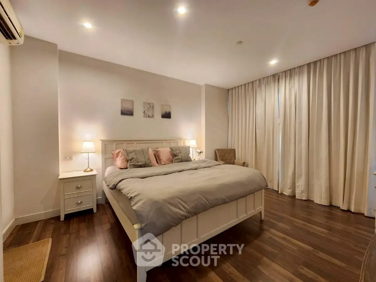 Spacious bedroom with elegant decor and cozy lighting in modern apartment.