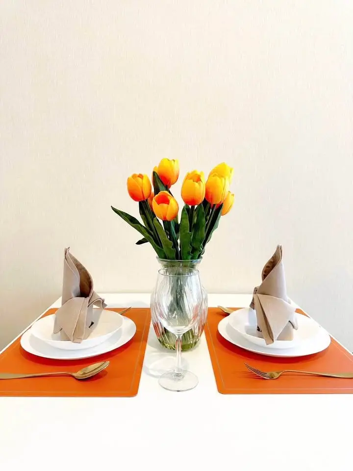 Elegant dining setup with vibrant tulips and stylish tableware, perfect for modern interiors.