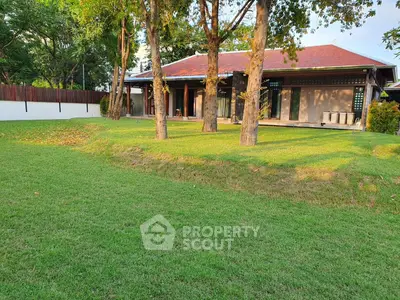 Charming single-story home with lush green lawn and mature trees, perfect for serene outdoor living.
