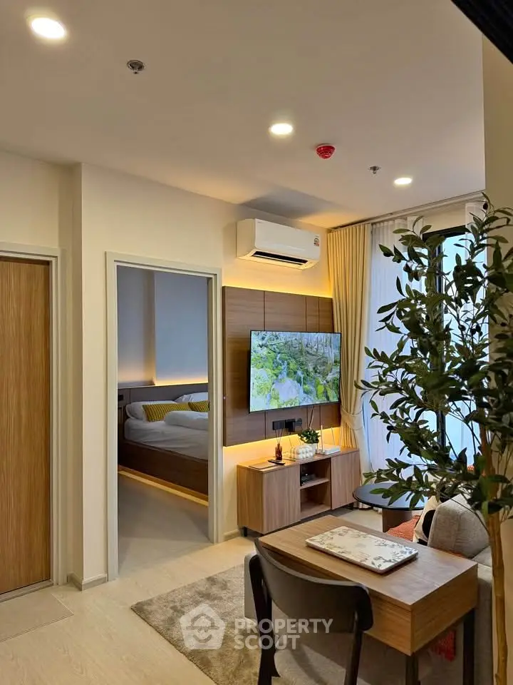 Modern living room with stylish decor and open view into cozy bedroom