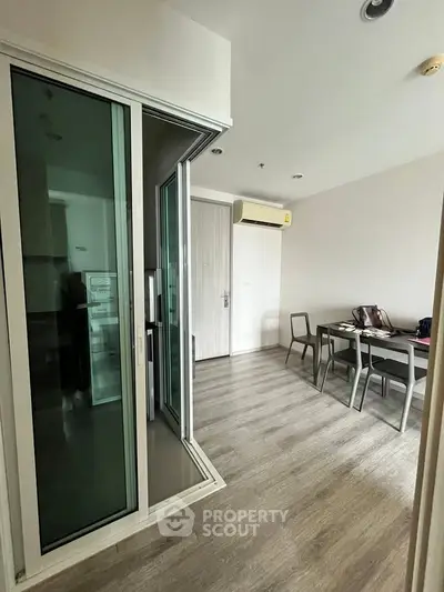 Modern apartment interior with sliding glass doors and stylish dining area.
