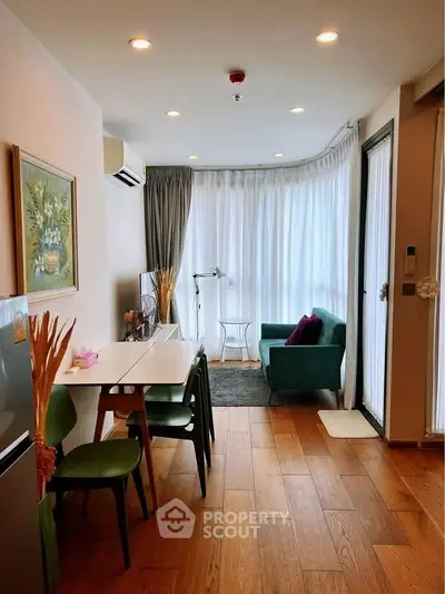 Charming living room with wooden floors, cozy seating, and natural light.
