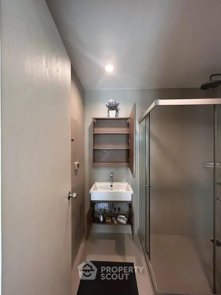 Modern bathroom with sleek shower and stylish sink in a contemporary apartment.