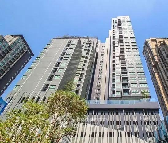 Stunning modern high-rise building with sleek architecture and lush greenery, perfect for urban living.
