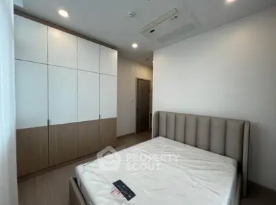 Modern bedroom with stylish bed and built-in wardrobe in a contemporary apartment.