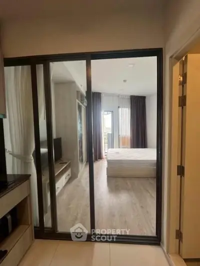 Modern bedroom with sliding glass doors and natural light, featuring a cozy bed and stylish decor.