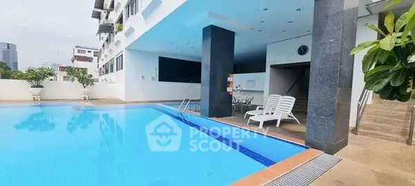 Luxurious apartment pool area with modern design and relaxing lounge chairs.