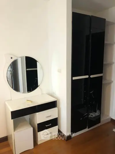 Modern bedroom with sleek black wardrobe and stylish vanity set